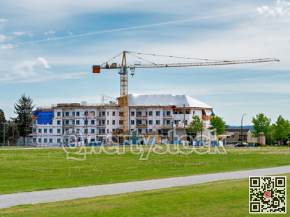 New low-rise residential building under construction on blue sky background