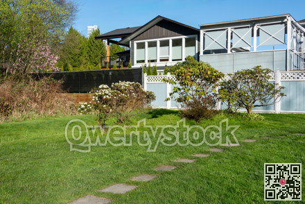 Back yard of residential house with open patio and green lawn in front