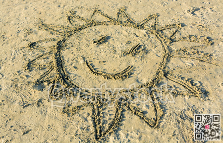 Child's drawing of smiling sun on yellow sand
