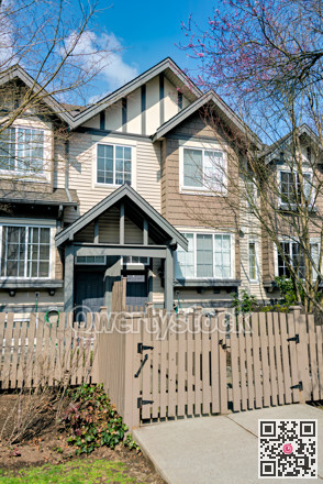 Residential townhouse entrance with wooden fence in front