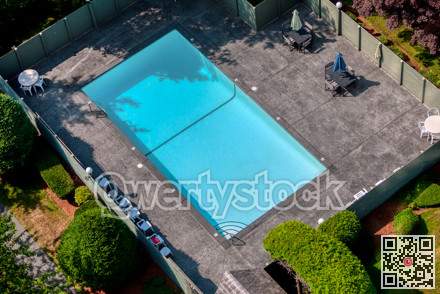 Outdoor swimming pool with emerald water and recreation area around