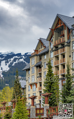 Residential building on snow-capped mountains background