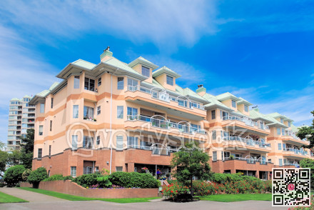 Low-rise residential building on bright sunny day and blue sky background