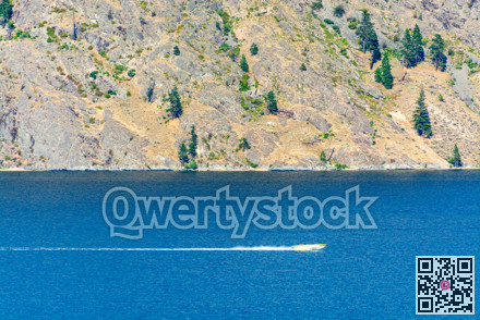 Power motor boat running over the lake with passengers on the board