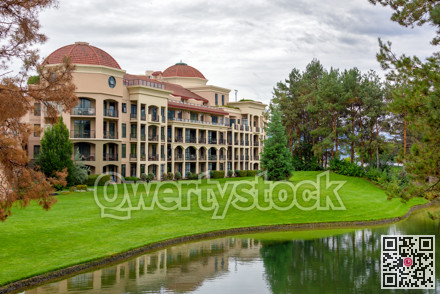 Luxury resort building with green lawn in front on overcast sky background