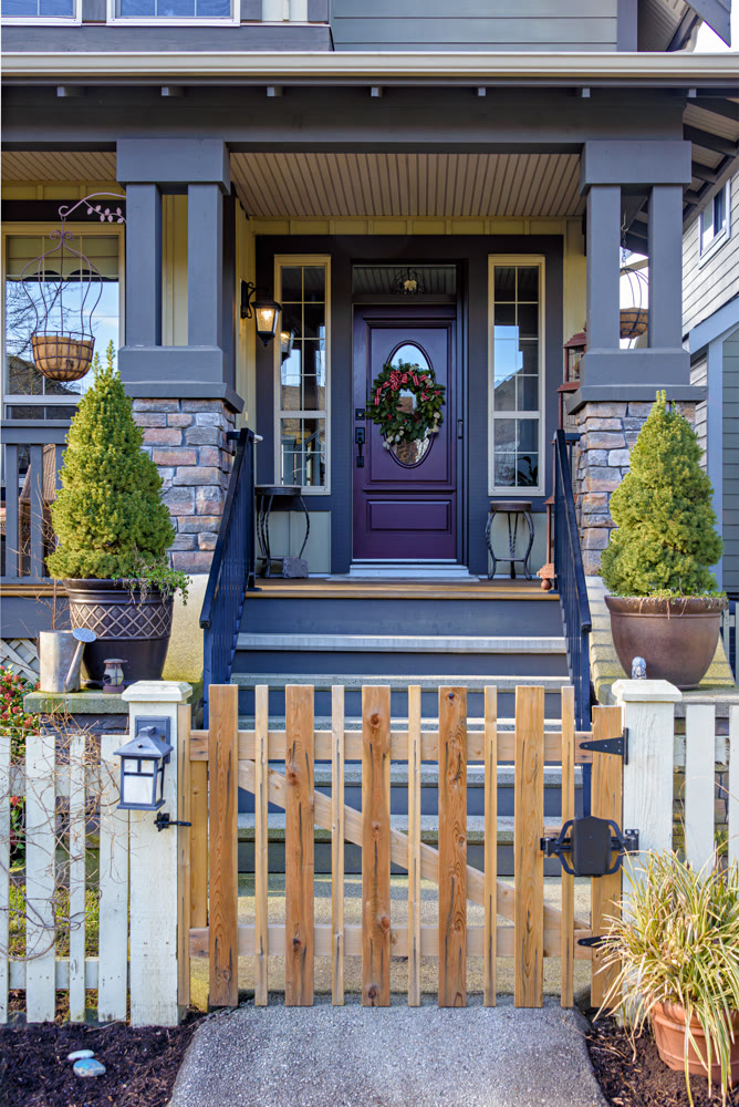 Entrance of luxury residential house with unpainted wooden gate in front