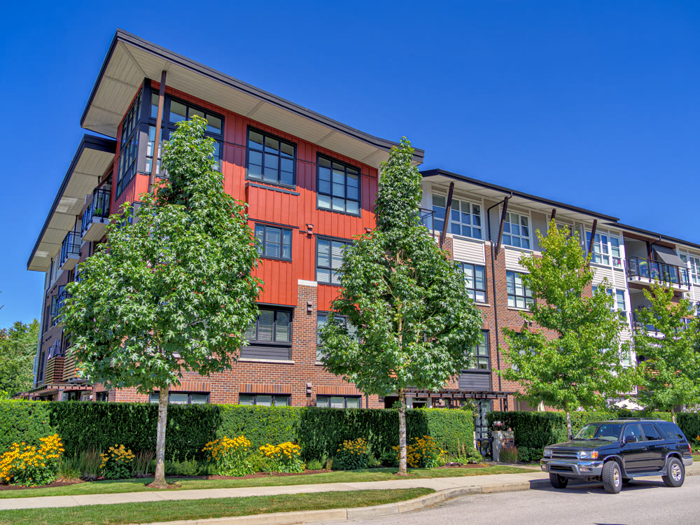 New residential apartment building with a truck parked on the roadside.