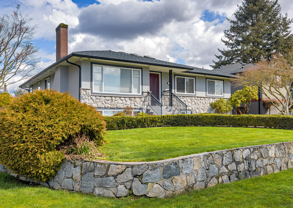 Average residential house with green lawn on land terrace in front