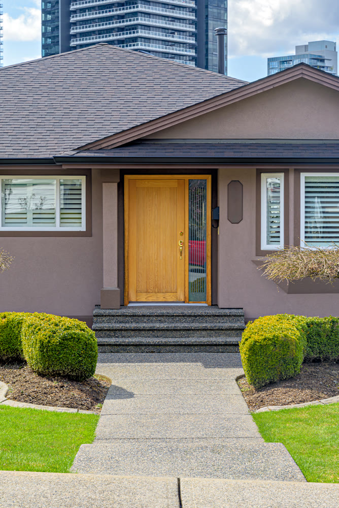 Neat entrance of a family house on residential high-rise buildings background
