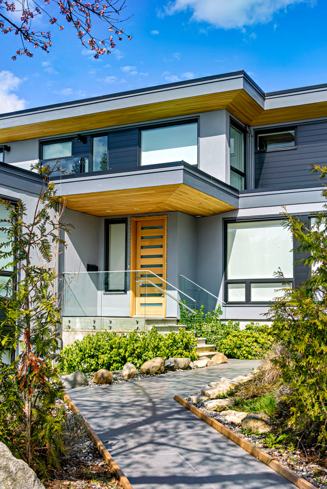 Neat entrance of modern residential house on blue sky background