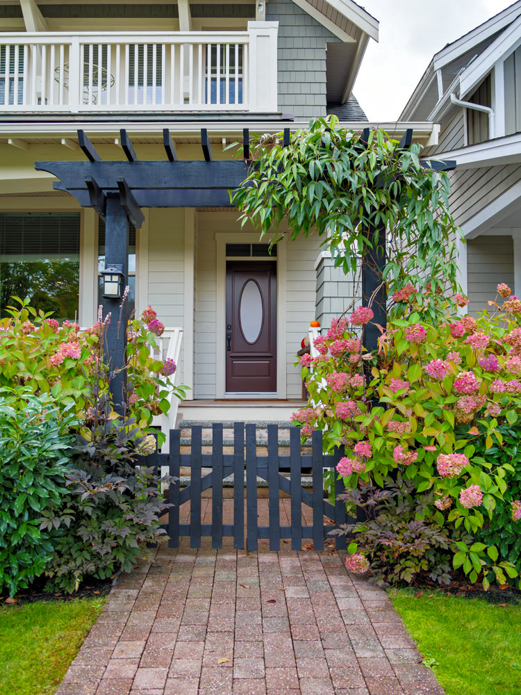 Entrance of luxury residential house with unpainted wooden gate in front