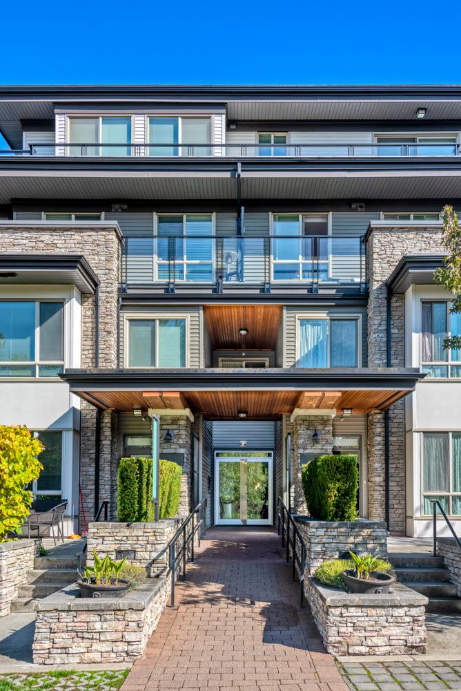 Entrance of residential apartment building with paved pathway in front