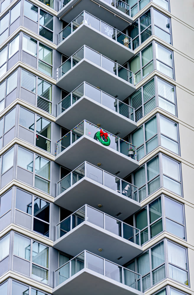 Corner of a residential high-rise building with balconies decorated for Christmas