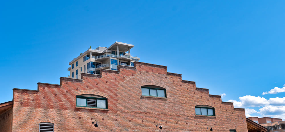 Brick wall of historic building with modern building on the back