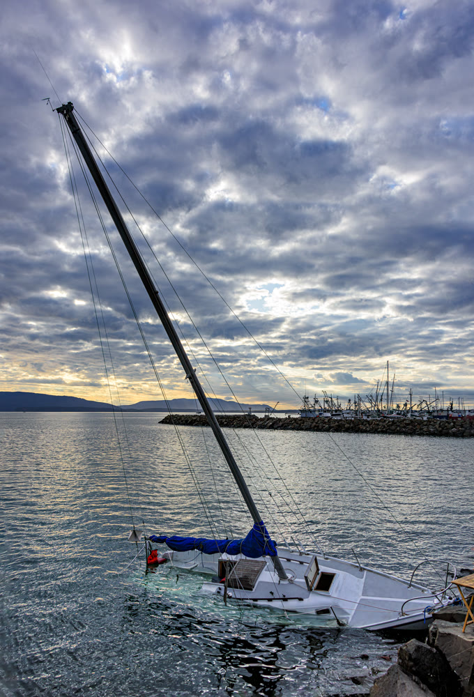 White yacht sinking in Pacific Ocean bay