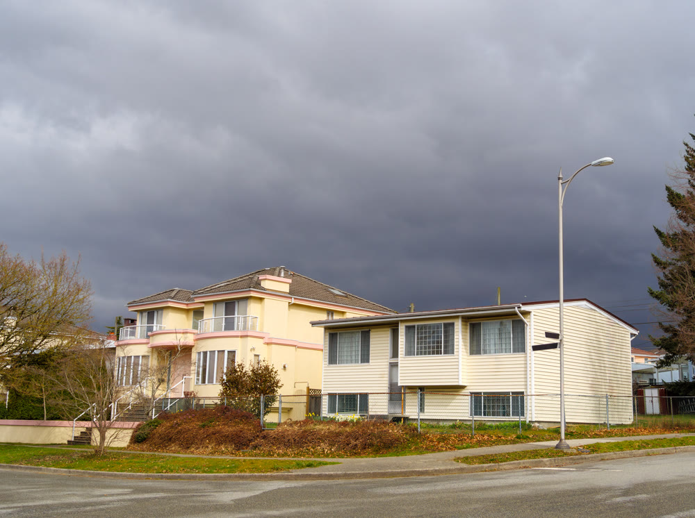The street corner with two residential houses on stormy sky background