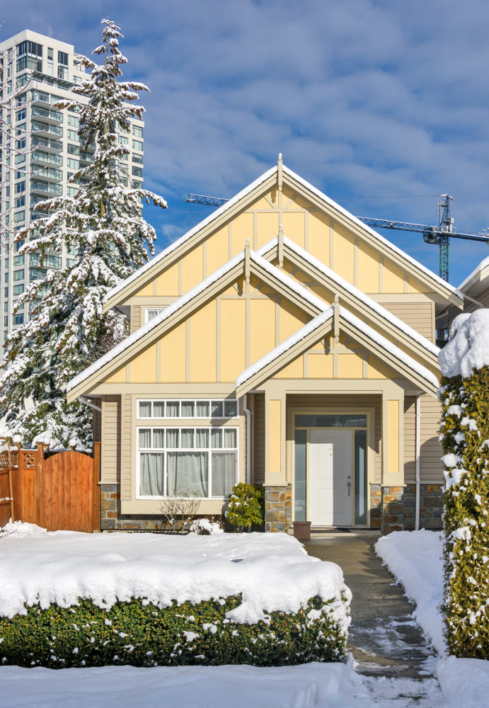 Modern high-rise and private residential house in snow on winter season