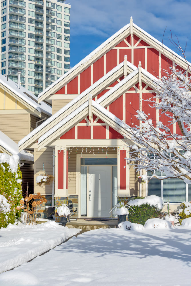 Modern high-rise and private residential house in snow on winter season