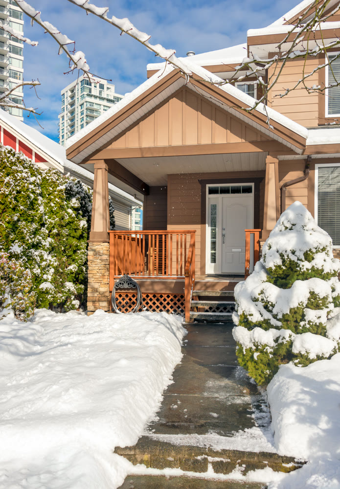 Modern high-rise and private residential house in snow on winter season