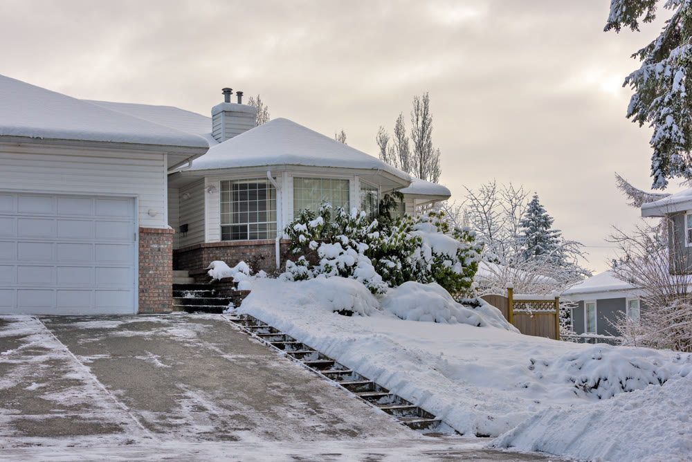 Big residential house with rotonda in snow on overcast winter day