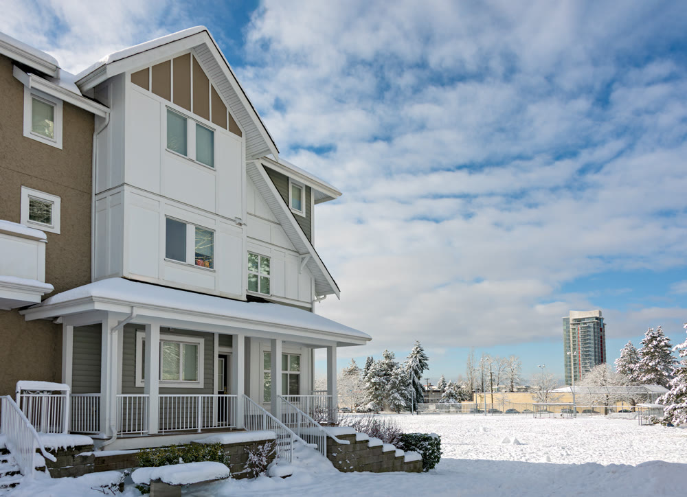 Residential townhouses and high-rise building on bright winter day with cloudy sky background