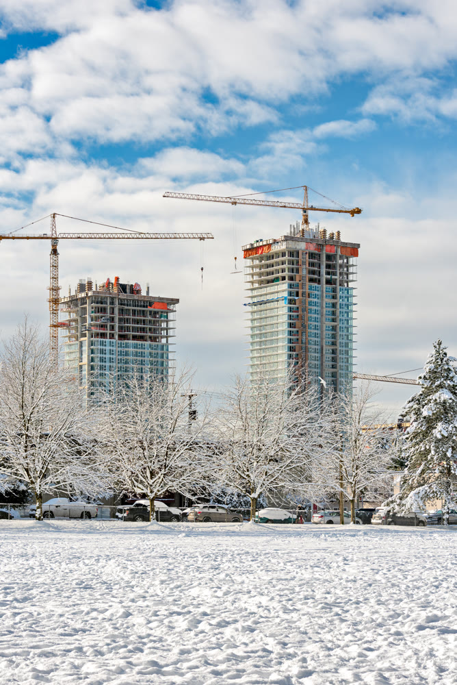 New high-rise residential buildings under construction on bright winter day