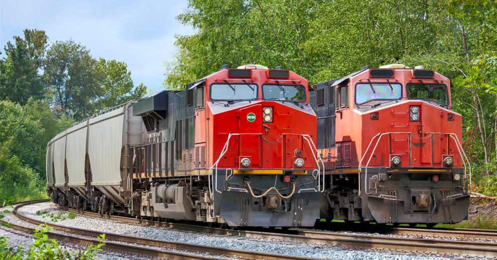 Two red locomotives are waiting for the semaphore signal