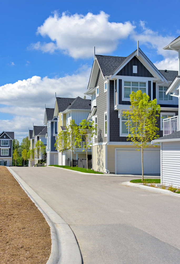 A perfect neighborhood. Brand new townhouses district on blue sky and clouds background