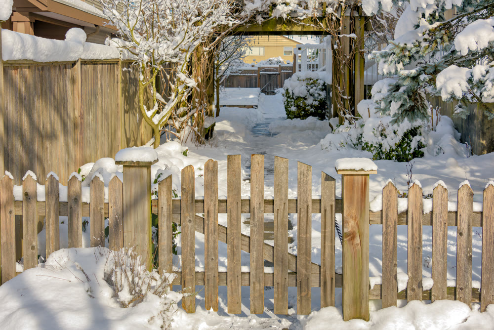 Wooden fence and gate of residential area entrance on bright winter day