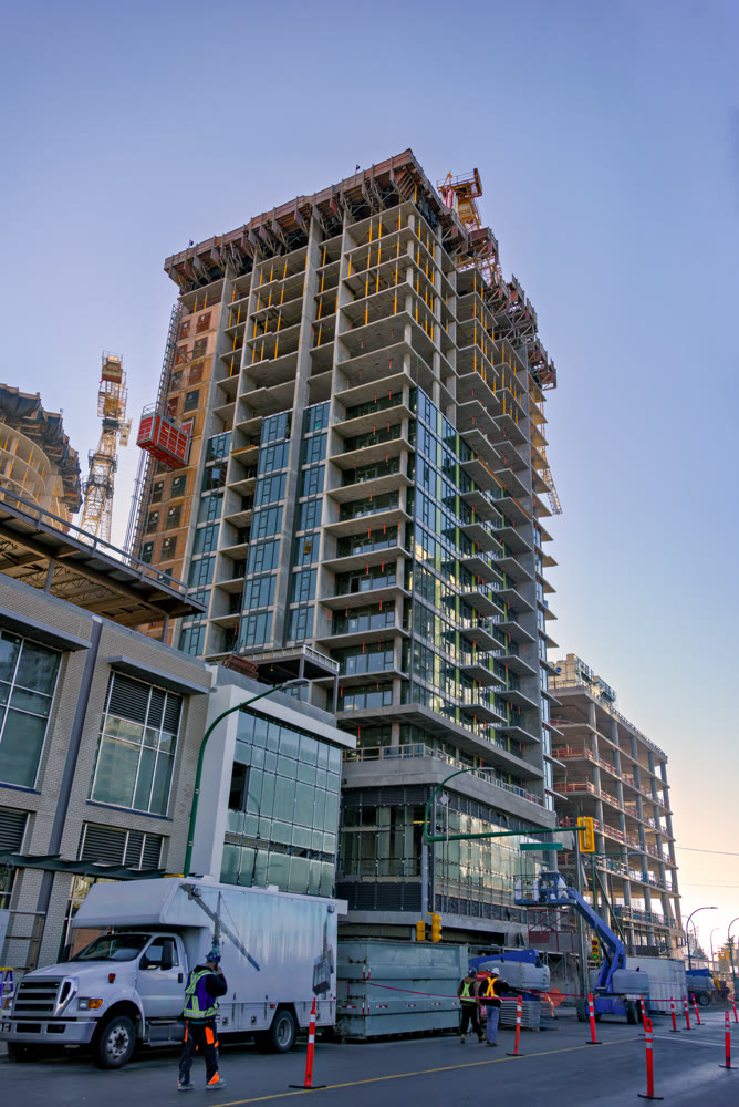 High-rise buildings under constraction with traffic management posts on the road