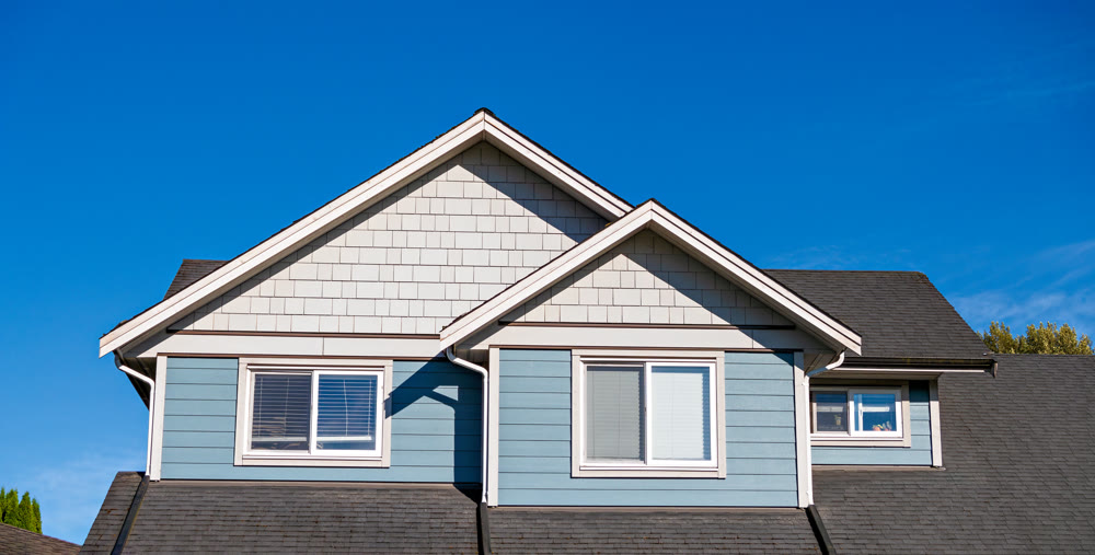 Top storey of residential house on blue sky background
