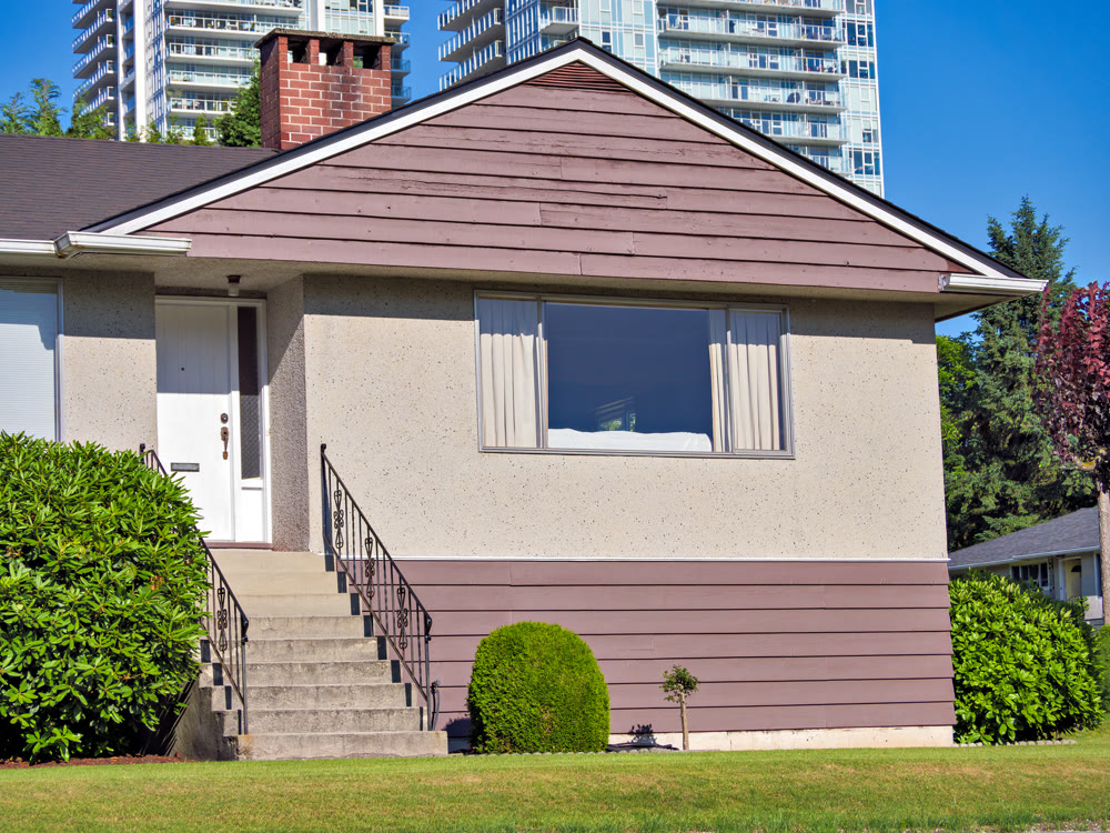 Green lawn and main entrance of average residential building in British Columbia, Canada