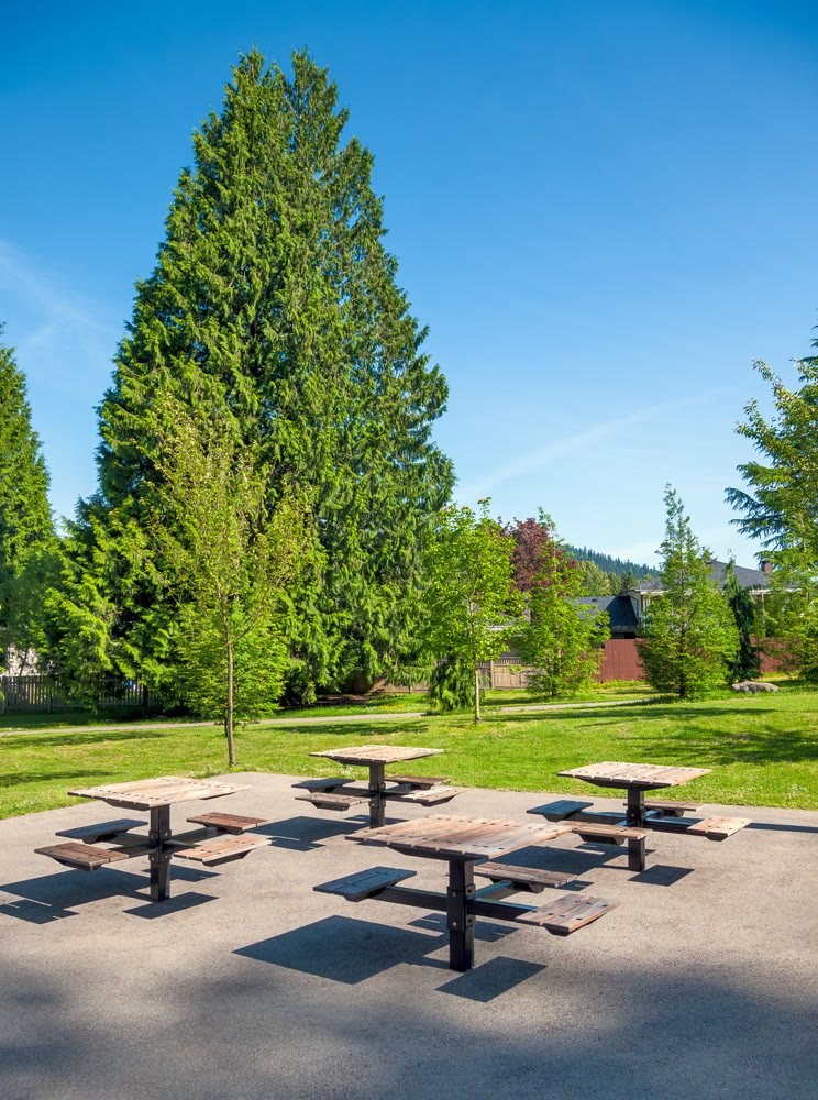 Small park with four tables and benches in a residential area