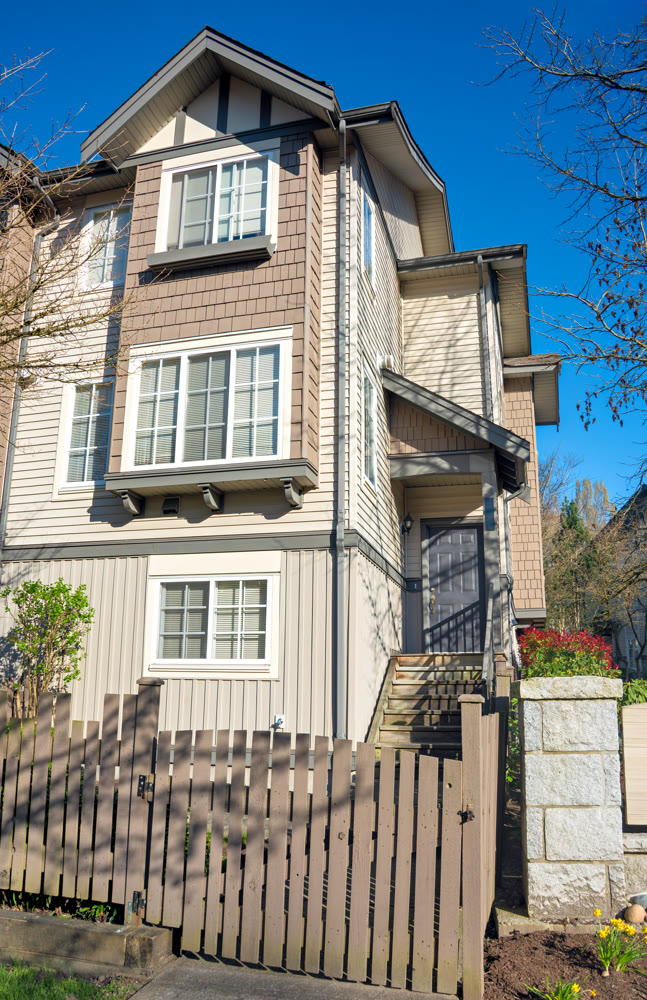 Residential townhouse entrance with wooden fence in front