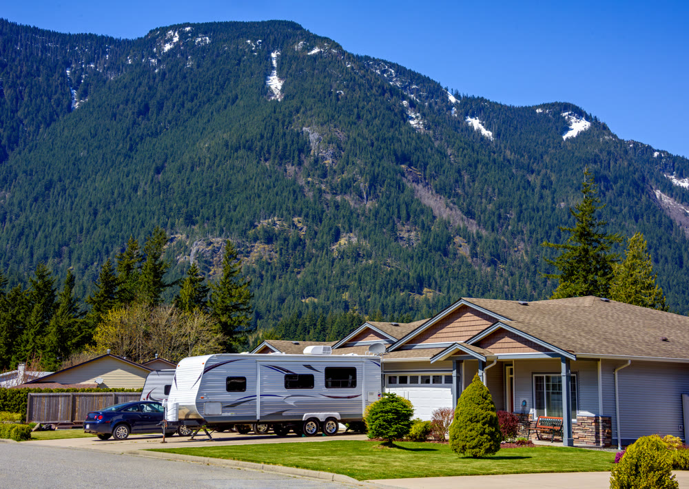 New luxury residential house with car and RV traler parked on driveway