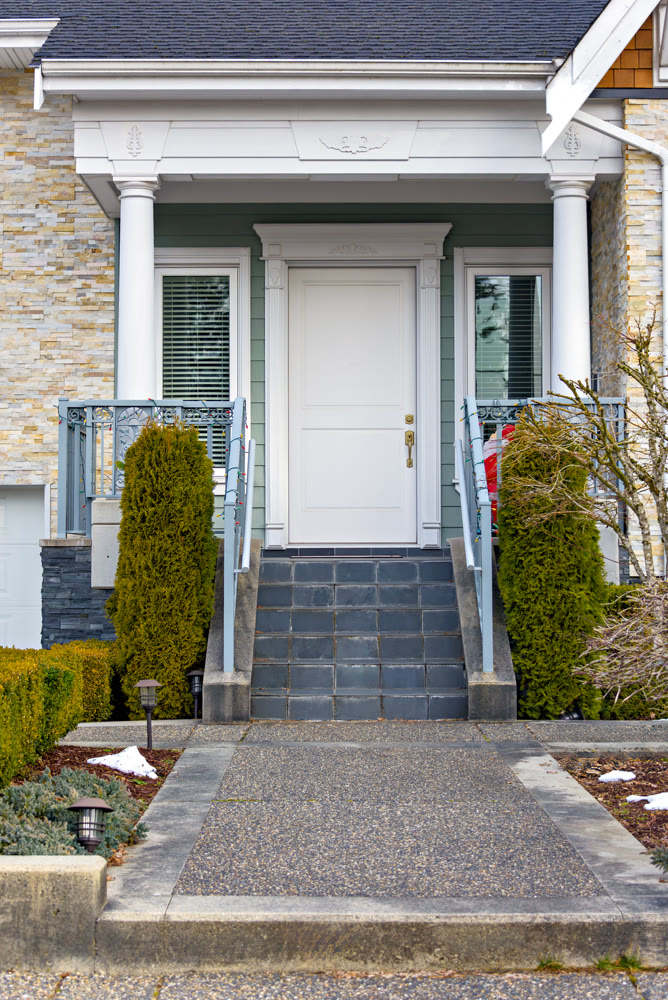 Entrance door of residential townhouse with doorsteps and pathway in front