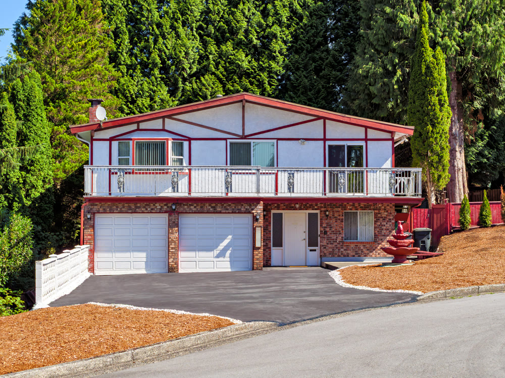 Family residential house with double garage and tall trees on the back yard