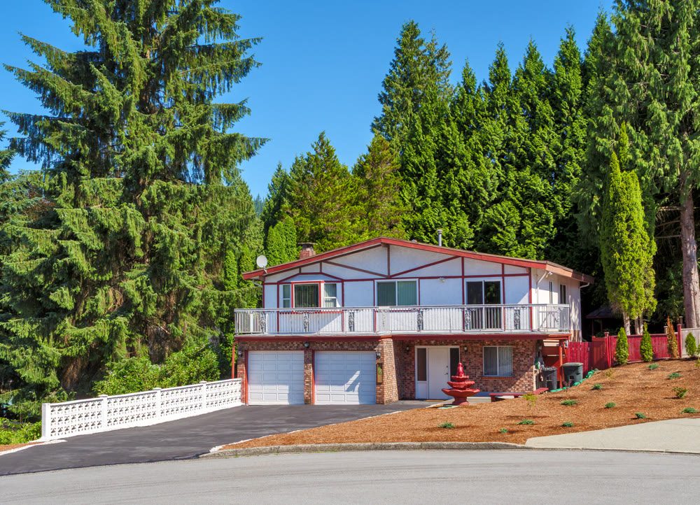 Family residential house with double garage and tall trees on the back yard