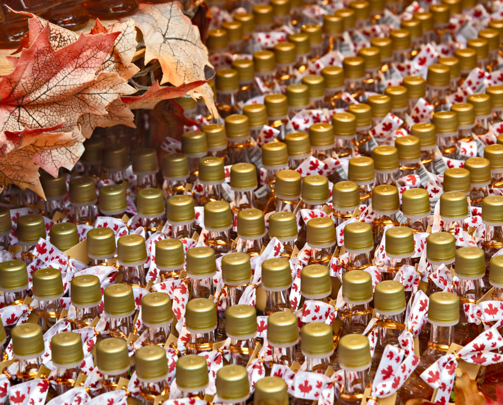 Rows of Maple leaf syrup bottles with decorative maple leaves on top