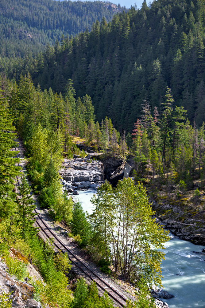 Mountain landscape with rail road and shallow river running through