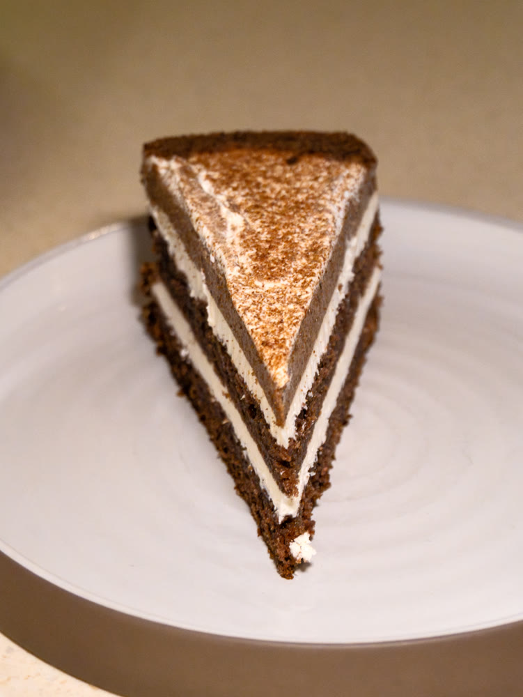 Piece of coffee cake with cream on the round plate