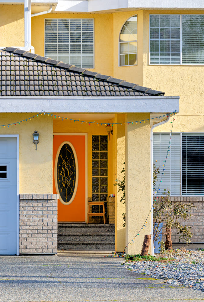 Orange door of residential house main entrance on bright sunny day