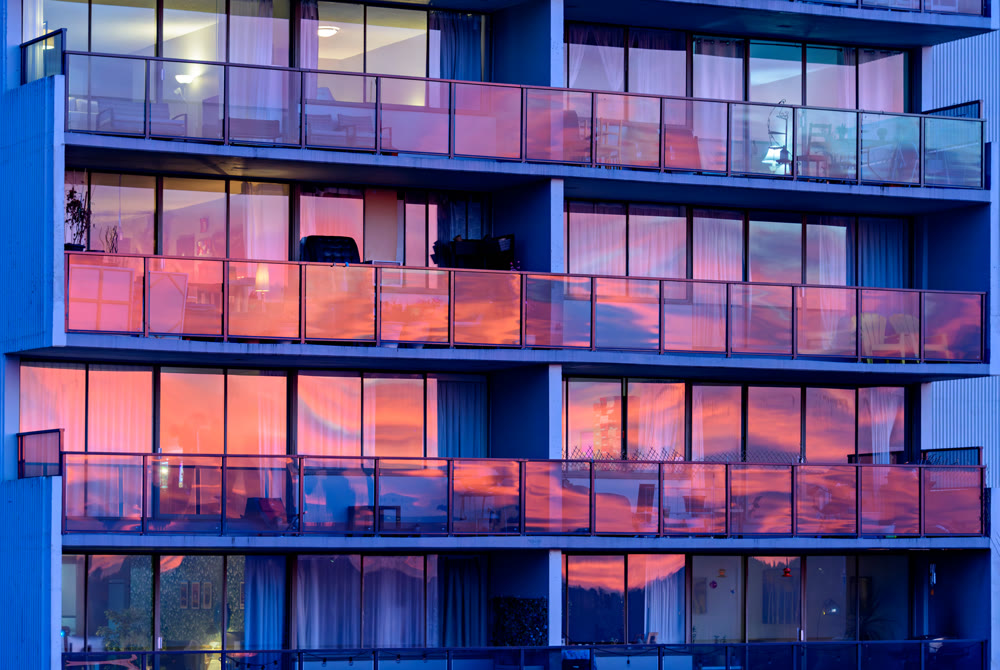 Colorful reflections of sunset in windows of residential building in Vancouver