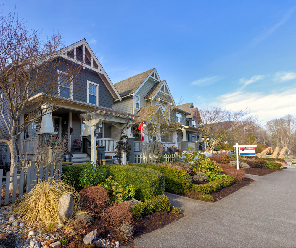 Row of residential houses with one house for sale on winter season in Canada