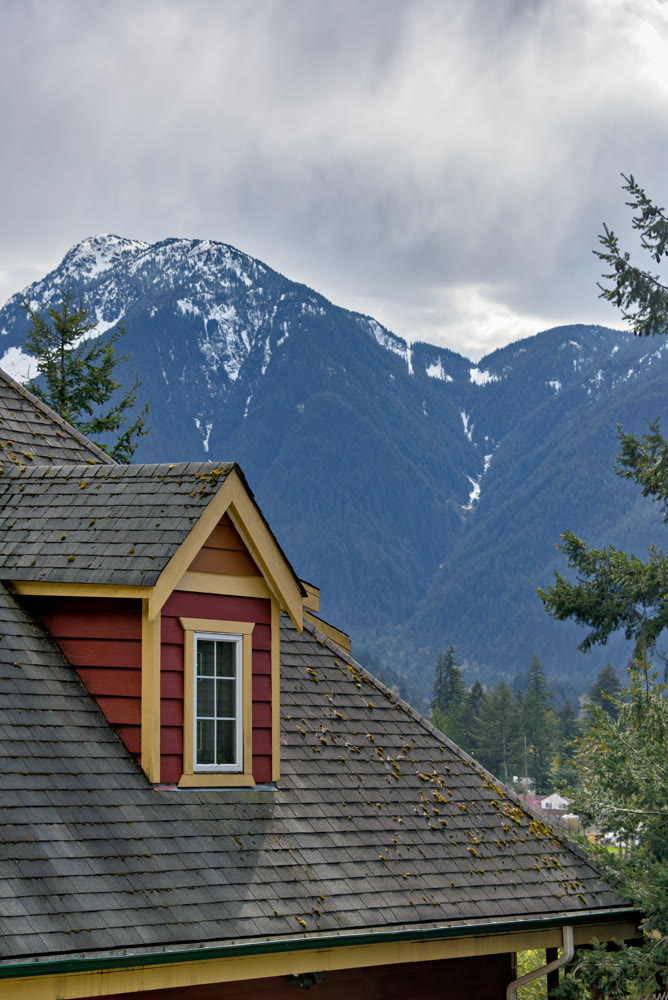 Top of residential house with mountain view and overcast sky background