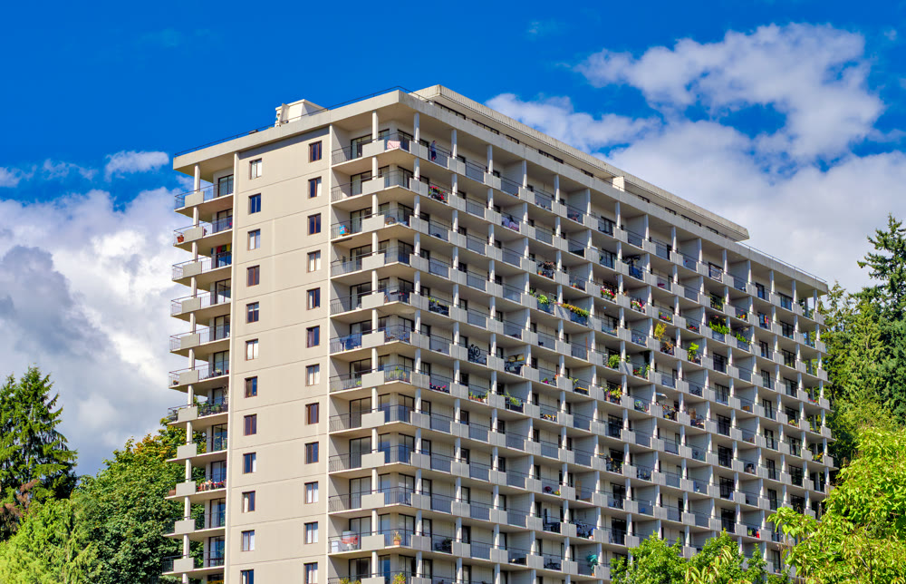 Back side of apartment residential building on blue sky background