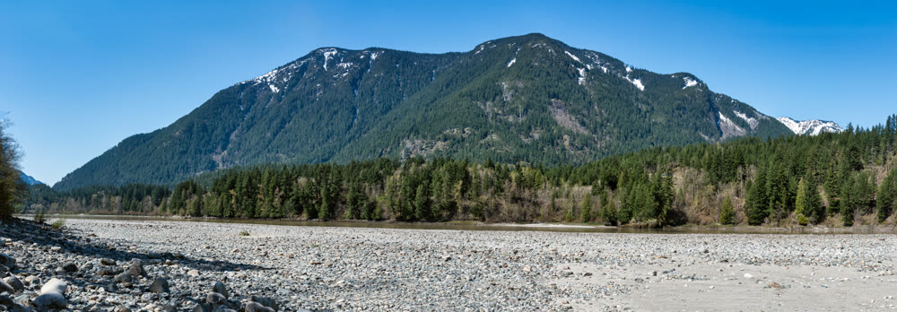 View at snowy mountains from stoney mountain riverbed in British Columbia