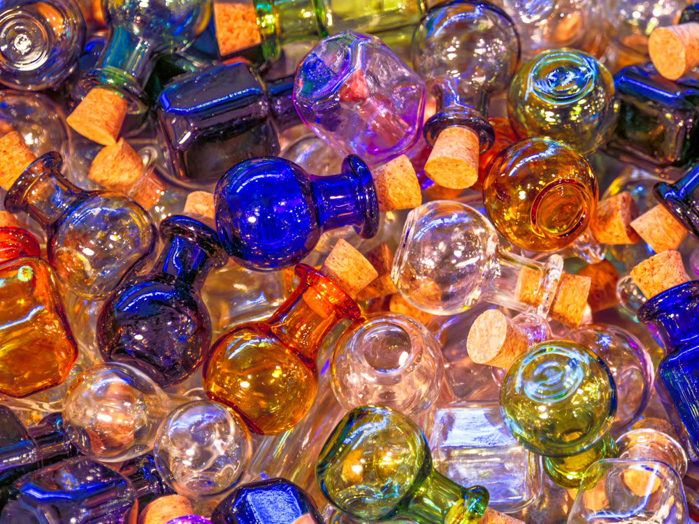 Small round colorful glass bottles closed with cork plugs