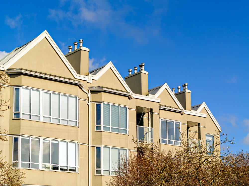 Top of low-rise residential building on blue sky background