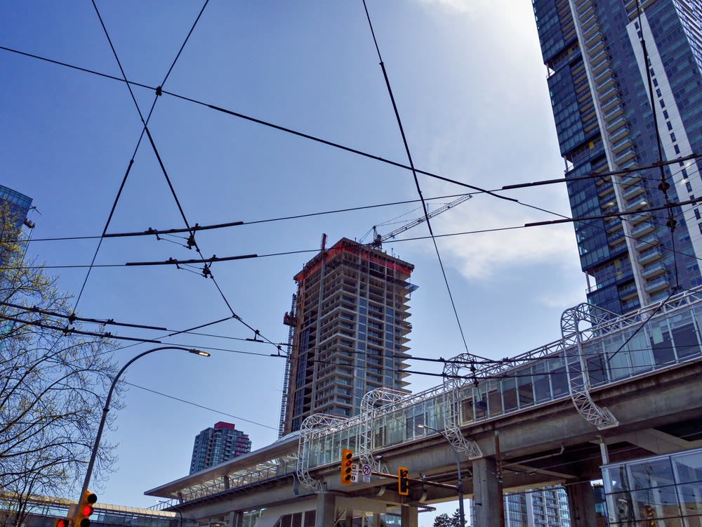 Urban view with power lines crossing blue sky background